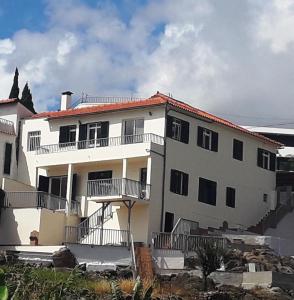 a large white building with balconies on it at Villa SCIROCCO Madeira - Ocean View in Machico