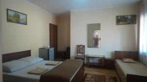 een kamer met 2 bedden en een bank. bij Садиба у Яноша in Vynohradiv