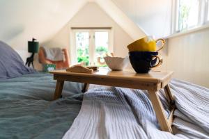 einen Couchtisch mit zwei Tassen auf dem Bett in der Unterkunft Gastenverblijf KortVertoef in Kortenhoef