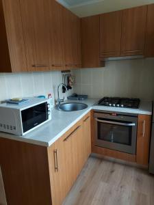 a kitchen with a microwave and a sink at Dzīvoklis in Ventspils