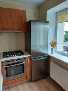 a kitchen with a stainless steel refrigerator and a stove at Dzīvoklis in Ventspils +11 photos