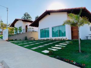 a house with a lawn in front of it at Chalés Recanto das Garças in Capitólio