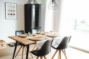 a dining room table with four chairs and a fireplace at Seeblick & Terrasse! Moderne Ferienwohnung 96qm in Großräschen