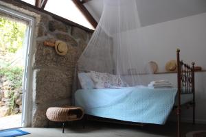 a bedroom with a bed with a mosquito net at Bosque dos Amieiros in Marco de Canavezes +61 photos