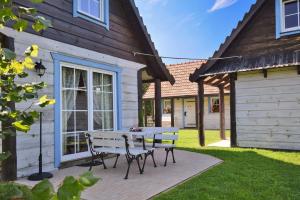 un patio con mesa y bancos frente a una casa en Wilkowa Chata, en Wilków