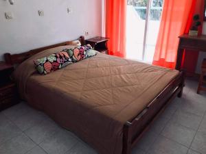 1 cama grande en un dormitorio con cortinas naranjas en Pension Zoi, en Kolymbia