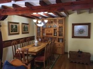 a dining room with a wooden table and chairs at Ermita de Gredos in Navarredonda de Gredos