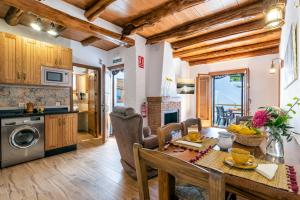 a kitchen and dining room with a dining table and a kitchen with a stove at Apartamentos Entre Senderos in Capileira