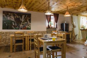 uma sala de jantar com mesas e cadeiras de madeira em Rustic Lodge Plitvice 1 em Plitvicka Jezera