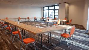 una sala de conferencias con una mesa larga y sillas en Hotel Amper, en Germering