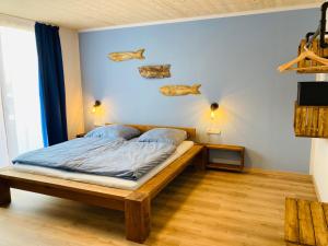 1 dormitorio con 1 cama con pescado en la pared en Ankerix & Deichfix, en Büsum