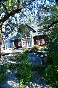 a house with a patio and a table in front of it at Naturforsthaus Gartenblick für tier- und naturverbundene Menschen in Preitenegg