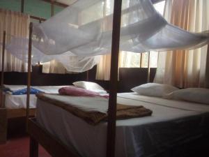 a bedroom with two beds with white sheets and pillows at Don Jaime - Hostel in Puerto Maldonado