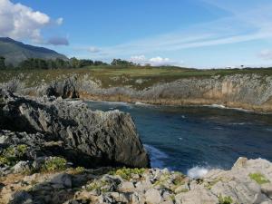 a view of a river with rocks and water at nueva el bosquin in Nueva de Llanes