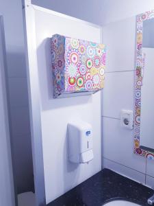 a bathroom with a toilet paper dispenser on the wall at Montevideo Port Hostel in Montevideo