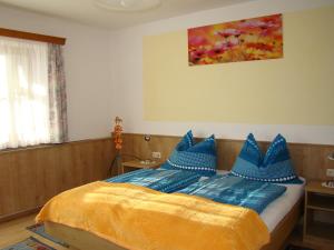 ein Schlafzimmer mit einem Bett mit blauen Kissen darauf in der Unterkunft Urlaub am Bauernhof Blamauer Köhr in Göstling an der Ybbs