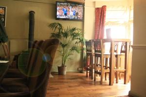 a living room with a table and chairs and a tv at Duke Of Wellington in Matlock