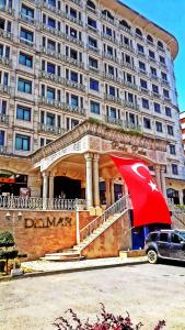 un grand bâtiment avec un parapluie rouge devant lui dans l'établissement SABIHA GOKCEN HOTEL İSTANBUL HOUSES, à Istanbul