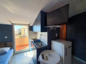 a small kitchen with a refrigerator and a tv at Apartments Milka in Dobra Voda +35 photos