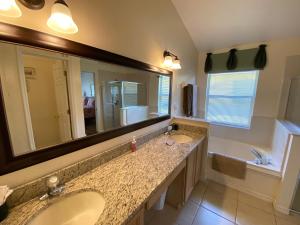 baño con 2 lavabos y espejo grande en Platinum Vacation Homes en Kissimmee
