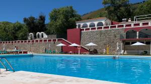 a large swimming pool in front of a building at Casas de Alpedrinha in Alpedrinha