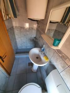a small bathroom with a sink and a toilet at Apartments Milka in Dobra Voda