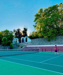 a person playing tennis on a tennis court at Casas de Alpedrinha in Alpedrinha