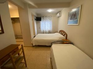 カルプにあるPension El Parqueのベッド2台と窓が備わる小さな客室です。