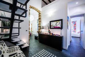 uma sala de estar com uma escada em espiral e um quarto com paredes brancas em White em Palermo