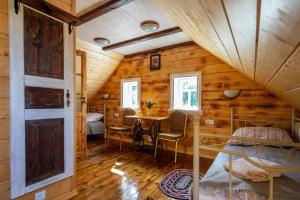 a room with a bed and a table in a cabin at SOWA Stara Plebania w Werstoku na Podlasiu in Werstok