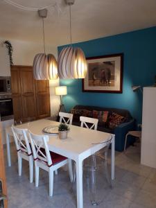 ein Wohnzimmer mit einem weißen Tisch und Stühlen in der Unterkunft Casa Paola e Guido in Posada