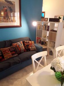 ein Wohnzimmer mit einem Sofa und einem Tisch in der Unterkunft Casa Paola e Guido in Posada