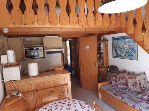 a small kitchen with wooden cabinets and a table at Les Perthuis - Portes du Soleil in Châtel
