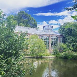 a large glass greenhouse next to a body of water at Amstel Boutique Studio in Amsterdam