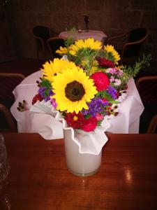 um vaso branco cheio de flores sobre uma mesa em Hotel-Restaurant Bibermühle GmbH em Tengen