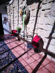 a table and chairs in front of a stone wall at Hotel-Restaurant Bibermühle GmbH in Tengen