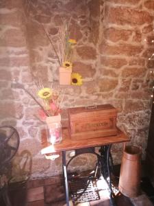 une table avec des fleurs et une boîte sur un mur dans l'établissement Hotel-Restaurant Bibermühle GmbH, à Tengen