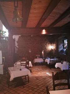 a restaurant with tables and chairs and a stone wall at Hotel-Restaurant Bibermühle GmbH in Tengen