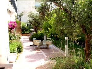 a patio with tables and chairs in a garden at Virgilio Grand Hotel in Sperlonga
