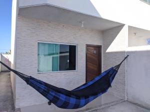 una hamaca azul colgada fuera de una casa en Duplex Cabo frio I, en Cabo Frío