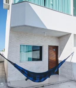 a blue hammock in front of a building at Duplex Cabo frio I in Cabo Frio