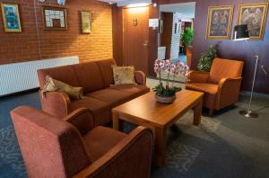 a waiting room with a couch and chairs and a table at Tähetorni Hotel in Tallinn
