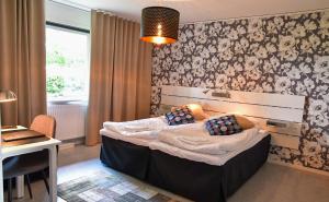 Un pat sau paturi într-o cameră la Wisingsö Hotell