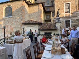 a group of people sitting at tables in front of a building at Il Sole in Bergamo