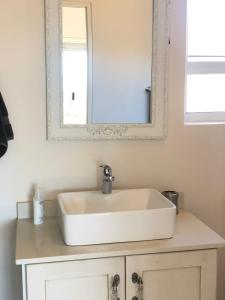 a bathroom with a sink and a mirror at Views at 69 B&B in Langebaan