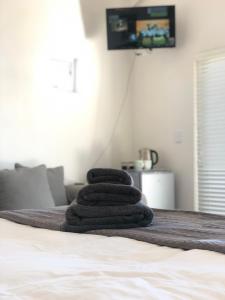 a stack of towels sitting on top of a bed at Views at 69 B&B in Langebaan
