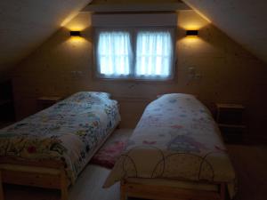 a bedroom with two beds and a window at Le Chalet in Aywaille