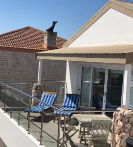 a patio with two chairs and a table on a balcony at Views at 69 B&B in Langebaan