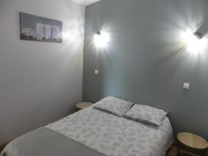 a bedroom with a bed and two lights on the wall at charmant studio 35m² au calme proche du circuit in Saint-Gervais en-Belin