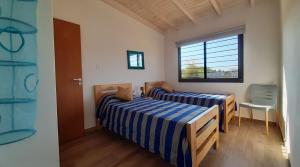 1 dormitorio con 2 camas y ventana en Cabañas Buena Vista - Santa Rosa en Santa Rosa de Calamuchita